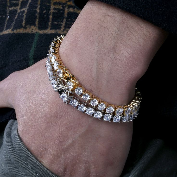 Two sparkling bracelets with alternating gold and silver links adorn a wrist.